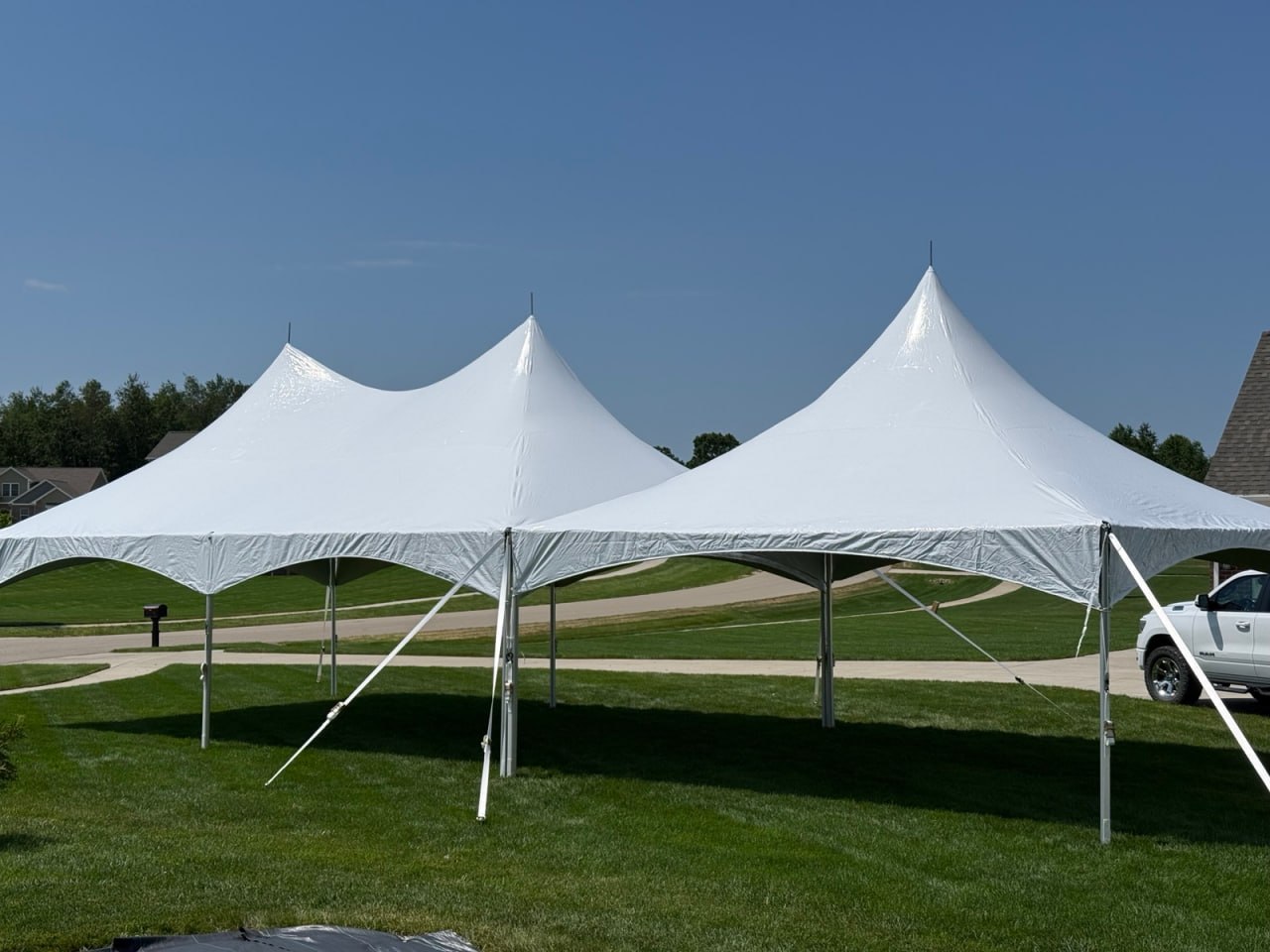 White high-peak event tents set up on a lawn